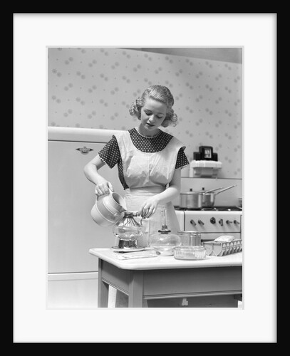 1930s Woman In Kitchen Wearing Apron Making Breakfast Pouring Water Into Coffee Pot by Anonymous