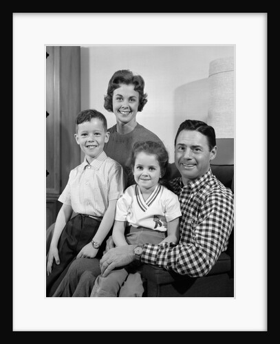 1960s Family Sitting On Couch Smiling Looking At Camera by Anonymous