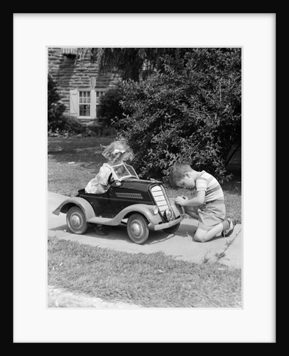 1940s 1930s Boy On Sidewalk Fixing Headlight Of Toy Car Driven By Little Girl Playing Outdoor by Anonymous