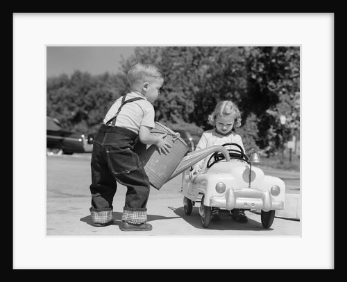 1950s Little Boy Playing Gas Station Pouring Water Into Toy Car For Little Girl by Anonymous