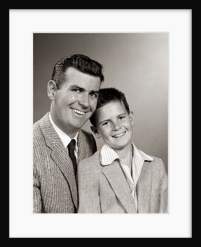 1950s Studio Portrait Smiling Man Father And Boy Son Sitting Together Looking At Camera by Anonymous