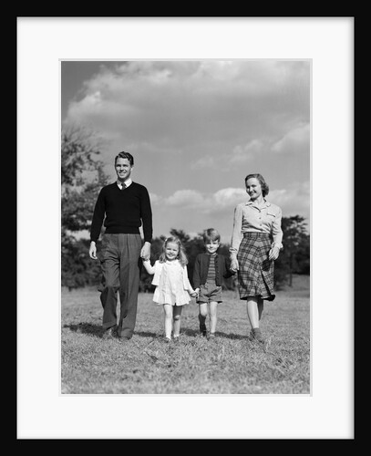 1940s Family Father Mother Son Daughter Holding Hands Together Walking On Grass by Anonymous