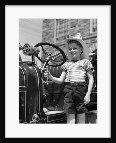 1930s Smiling Boy Standing Next To Fire Engine Wearing Firemans Hat by Anonymous