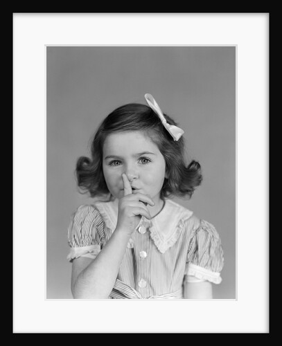 1940s Little Girl Looking At Camera Making Quiet Gesture Finger On Lips by Anonymous