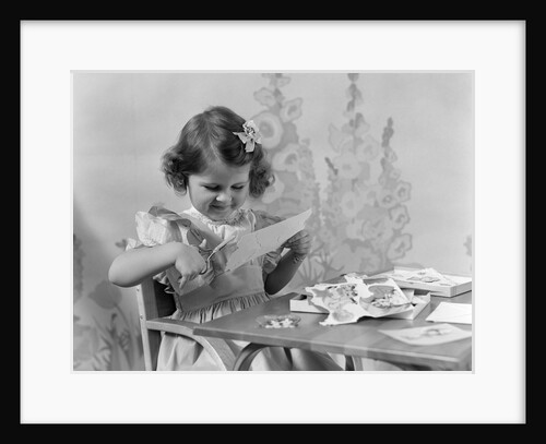 1940s Smiling Little Girl Cutting Paper With Scissors by Anonymous