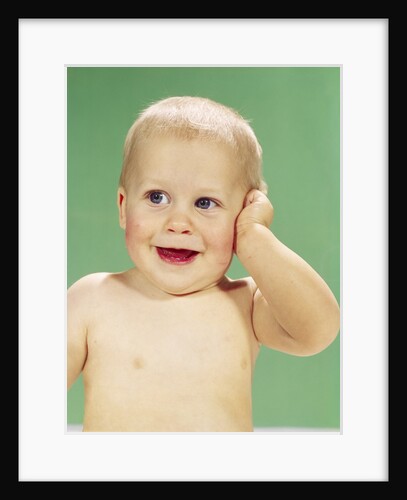 1960s Smiling Happy Baby Looking Off To The Side With Hand Touching Face by Anonymous