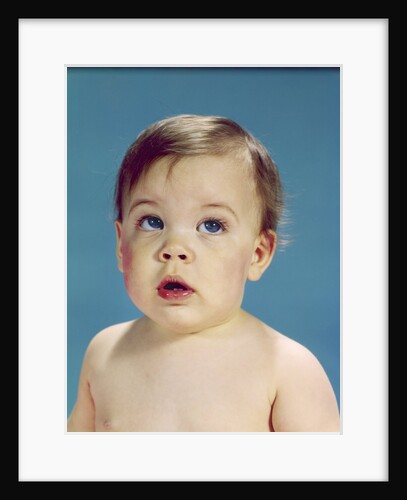 1960s Baby With Uncertain Facial Expression Deep Blue Eyes Looking Guilty Up And To The Side by Anonymous