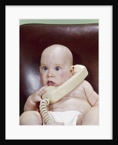 1960s Chubby Baby Sitting In Leather Office Chair Talking On Telephone by Anonymous