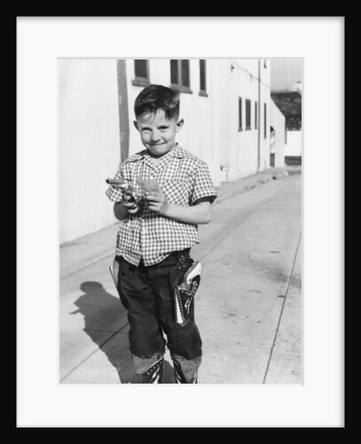 Young boy plays cowboy in a California alley, ca. 1952 by Anonymous