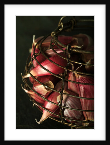 Garlic cloves in a rustic metal basket by Anonymous