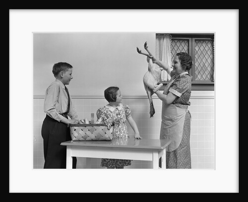 1940s housewife in kitchen showing plucked turkey to children by Anonymous