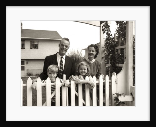 1950s family of four behind picket fence by Anonymous