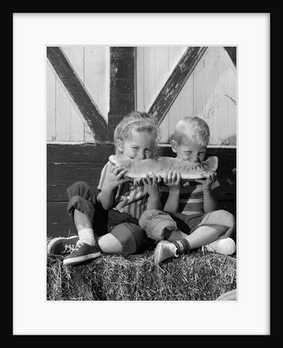 1960s boy and girl sharing a slice of watermelon by Anonymous
