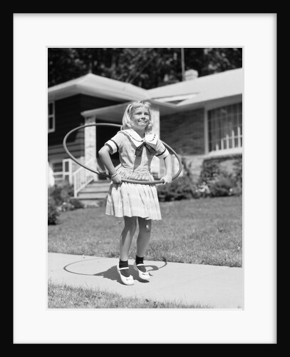 1950s girl on suburban sidewalk playing with a hula hoop by Anonymous