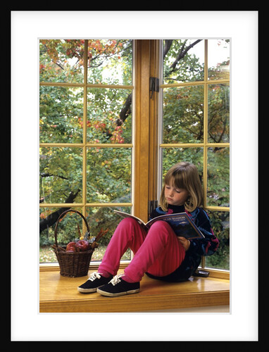 Little girl reading at home by Anonymous