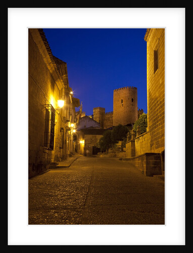 Streets of Banos de la Encina at night with the Moorish castle, named Burgalimar Castle, in the back by Anonymous