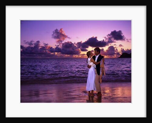 Dressed up couple embracing on the beach at sunset by Anonymous