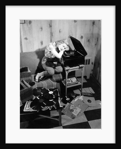 1950s teenage girl listening to music on a phonograph by Anonymous
