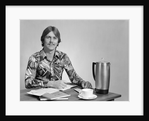 1970s smiling young man working on a budget by Anonymous