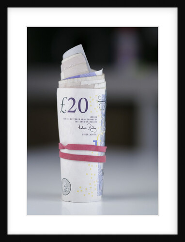 A roll of twenty pound notes on a table by Anonymous