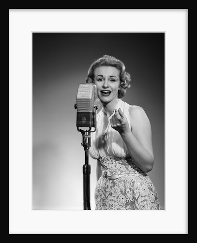1950s portrait of woman singing into a microphone by Anonymous
