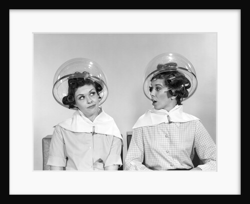 1960s two women sitting under hairdryers gossiping by Anonymous