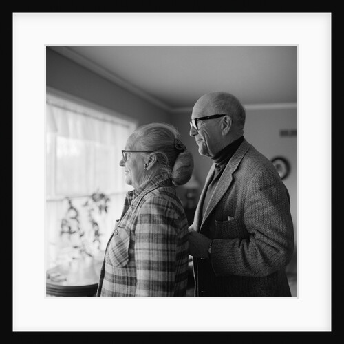 1970s senior couple looking out a window by Anonymous