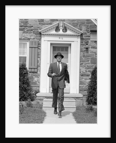 1950s smiling businessman walking out the front door of his house by Anonymous