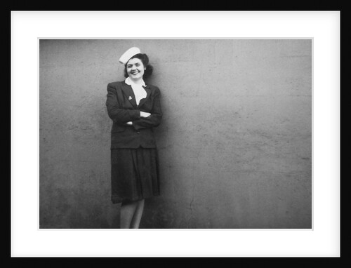 Young wife portrait against wall, ca. 1943. by Anonymous