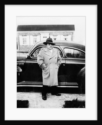Mature man stands by his car, ca. 1942. by Anonymous