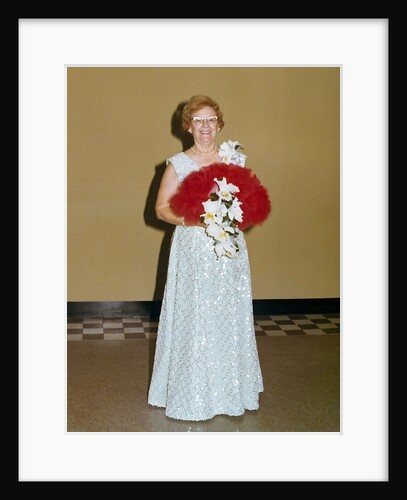 Senior woman with bouquet poses against wall, ca. 1970. by Anonymous
