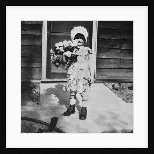Young girl with a bouquet of flowers on her doorstep, ca. 1928. by Anonymous