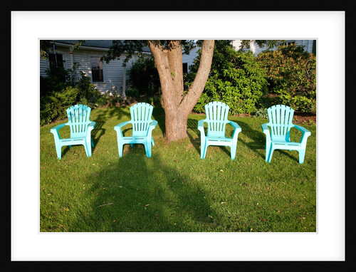 Turquois lawn chairs and green grass at sunset by Anonymous