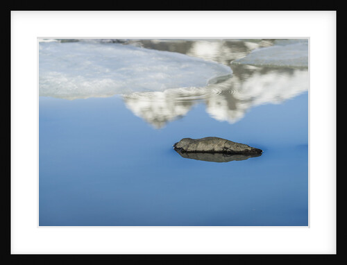 Rock with sky reflected in water. by Anonymous
