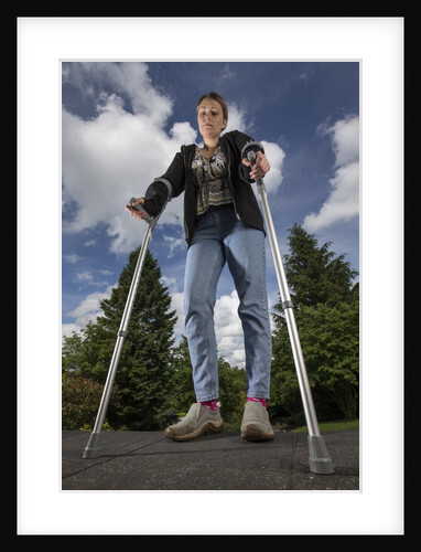 Woman standing on crutches by Anonymous