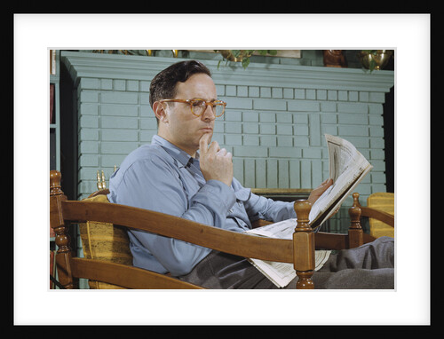 Pensive Man Reading Newspaper in Living Room by Anonymous