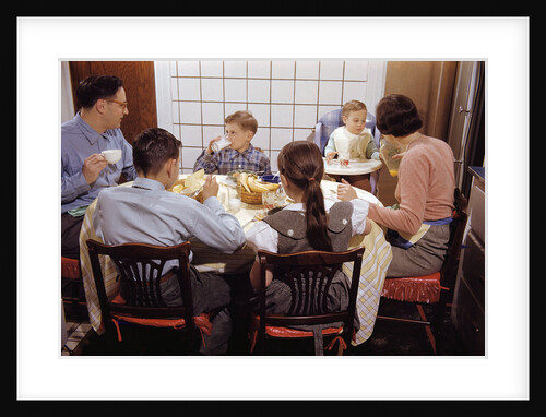 Family Eating Together at Dinner Table by Anonymous