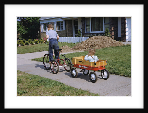 Boy Riding Tricycle and Towing Wagon by Anonymous