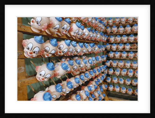 Clown Heads on Rack in Factory by Anonymous