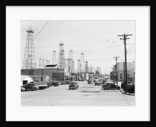 Clusters Of Oil Derricks Along Street by Anonymous