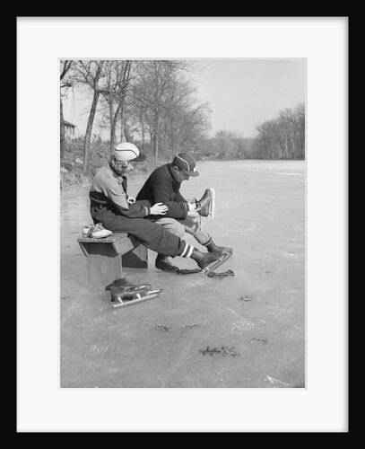 Man Puts Ice Skates On Woman At Rink by Anonymous