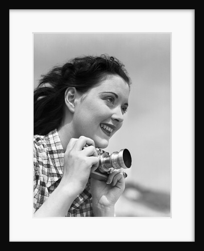 Woman Smiles as She Holds Camera by Anonymous