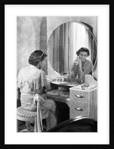 Young Woman Applying Face Cream at Vanity by Anonymous