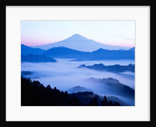 Distant view of Mount Fuji silhouetted against blue sky by Anonymous