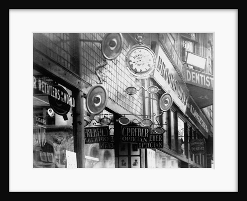 Clock and Eyeglass Signs In Front of Opticians Shop by Anonymous
