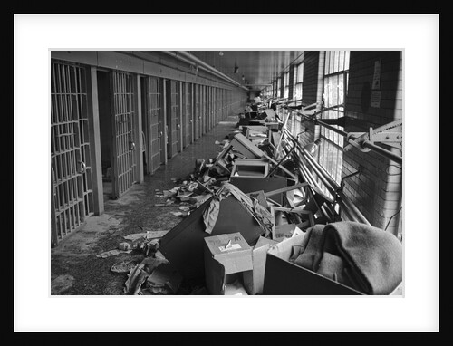Damaged Furniture and Debris in Prison Hallway by Anonymous