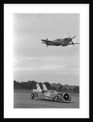 Airplane Flying Over Race Car in Action by Anonymous