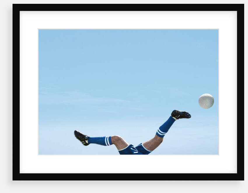 Soccer player upside-down attempting to kick the ball by Anonymous
