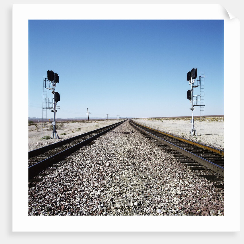 Railroad tracks running through desert setting by Anonymous