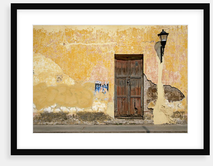 Broken Plaster on Yellow Wall with Old Wood Door by Anonymous